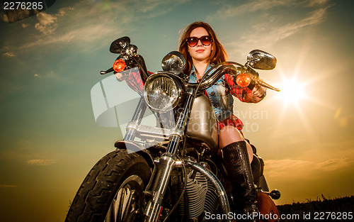 Image of Biker girl sitting on motorcycle