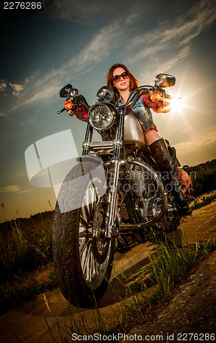 Image of Biker girl sitting on motorcycle