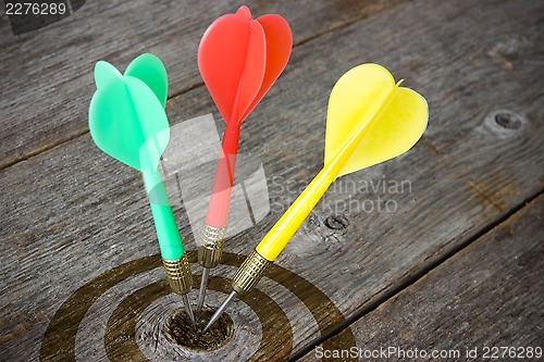 Image of Darts hitting  target on a wooden planks