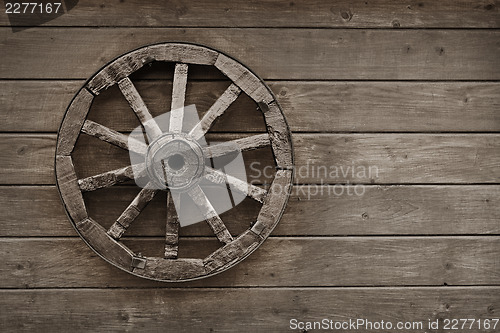 Image of Old wagon wheel on wooden wall