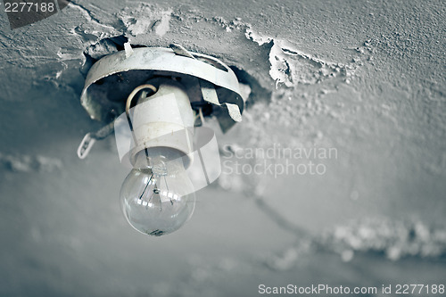 Image of Old light bulb on ceiling of abandoned house