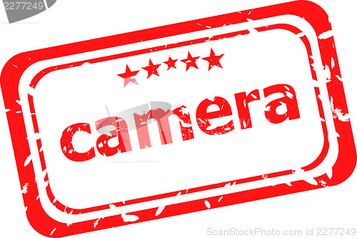 Image of camera on red rubber stamp over a white background