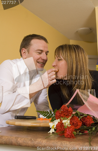 Image of happy couple cooking and kissing
