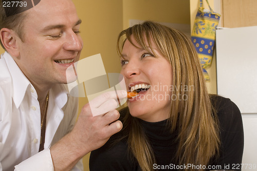 Image of happy couple cooking and kissing