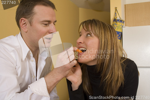 Image of happy couple cooking and kissing