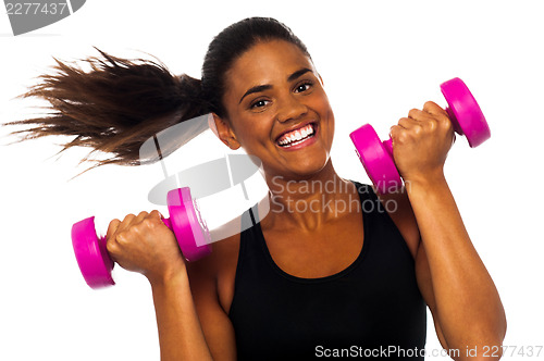 Image of Happy fitness woman lifting dumbbells