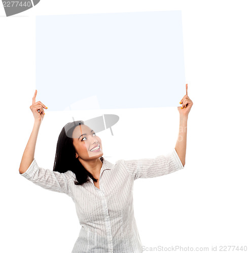 Image of Woman holding up a blank white billboard