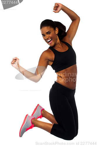 Image of Woman in sportswear jumping with joy