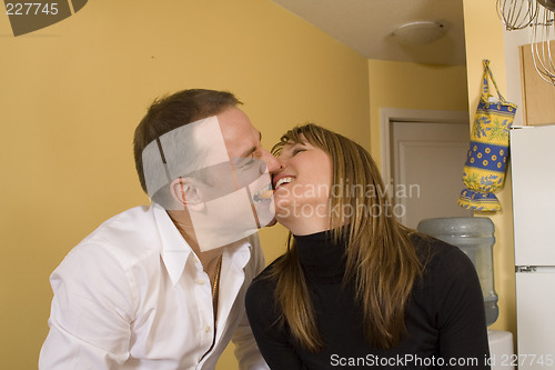 Image of happy couple cooking and kissing