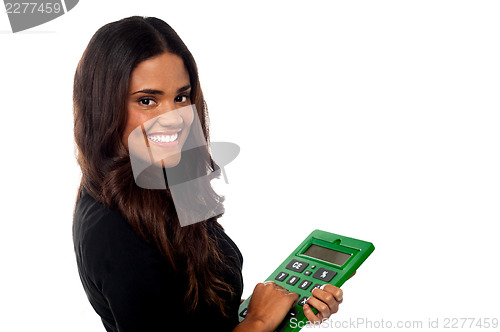 Image of Businesswoman operating big green calculator