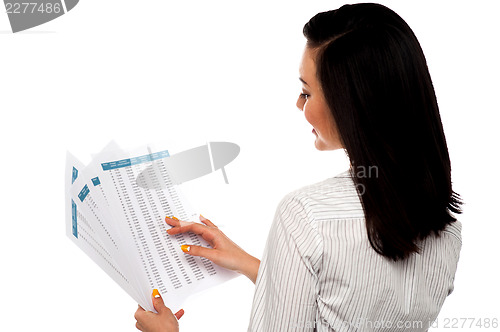 Image of Back pose of businesswoman reading reports