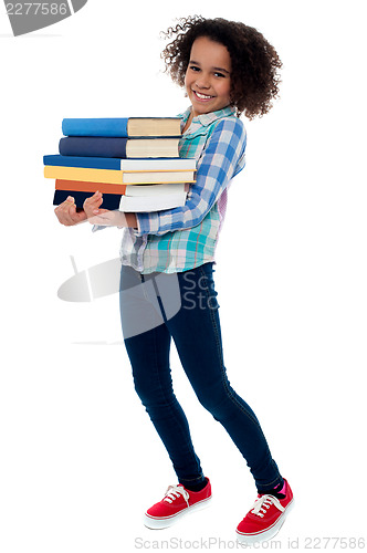 Image of Active young school kid carrying books