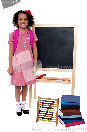 Image of Smiling school girl standing near the blackboard
