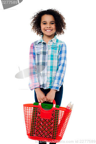 Image of Happy school girl carrying stationery in basket