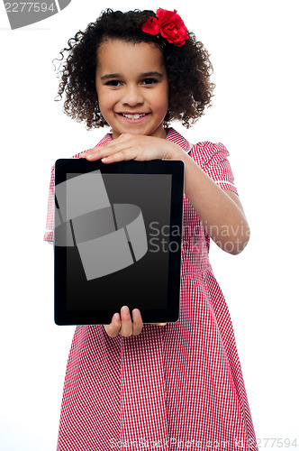 Image of Smiling african american girl presenting tablet pc