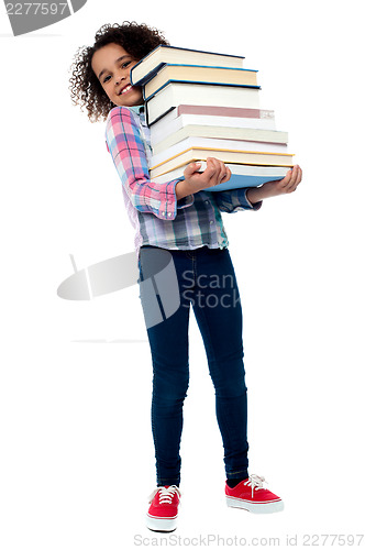 Image of Cute cheerful child carrying stack of books