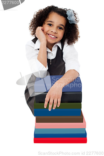 Image of Happy school girl with pile of books