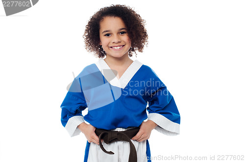 Image of Little girl adjusting her brown karate belt