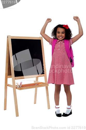 Image of Excited beautiful little girl in school uniform