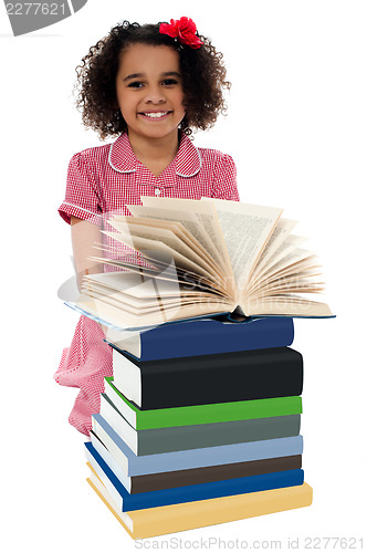 Image of Portrait of pretty schoolgirl reading textbook