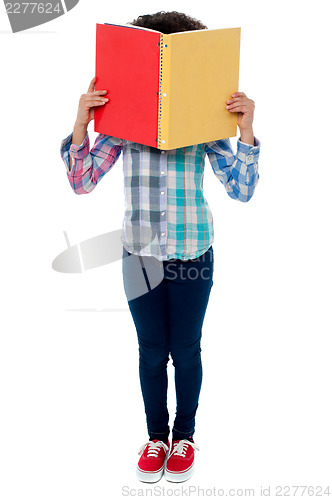 Image of School girl hiding her face with a book