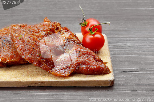 Image of raw steak with tomato