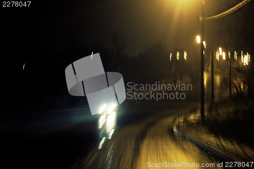 Image of Romantic night view of the road turn with lanterns. Blurred shot