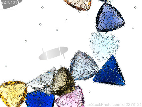 Image of Gems falling in pure water against white.