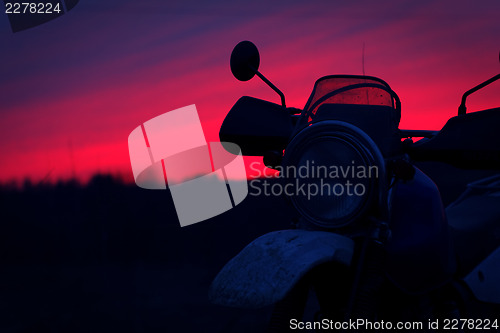Image of Silhouette of motorbike against sunset sky
