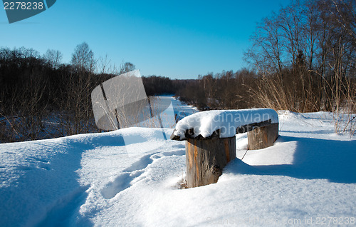 Image of Bench covered with snow in the rural