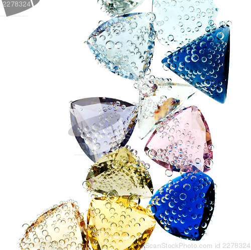 Image of Multi-colored gems falling into water isolated on white.