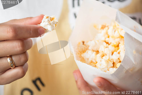 Image of Close up eating butter popcorn from popcorn pack 