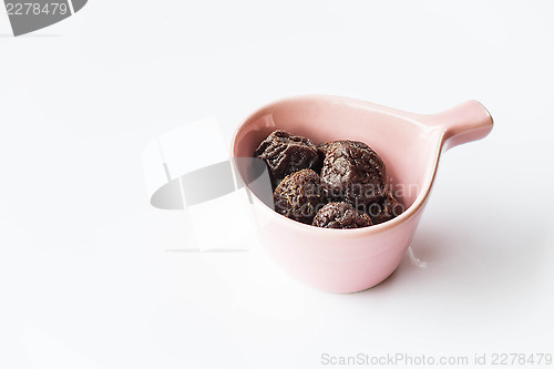 Image of Delicious dry pink plum in ceramic cup 