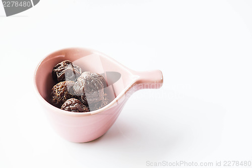 Image of Sweet dry pink plum in ceramic cup 