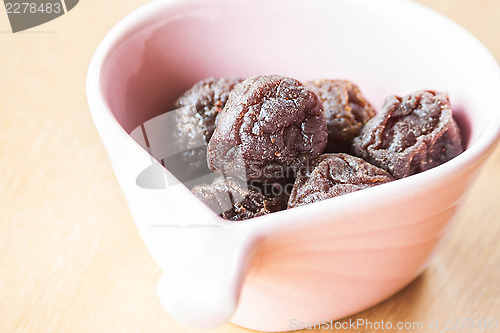 Image of Close up delicious dry pink plum in cup 