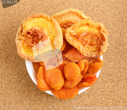 Image of Dried apricots and peaches on cork board