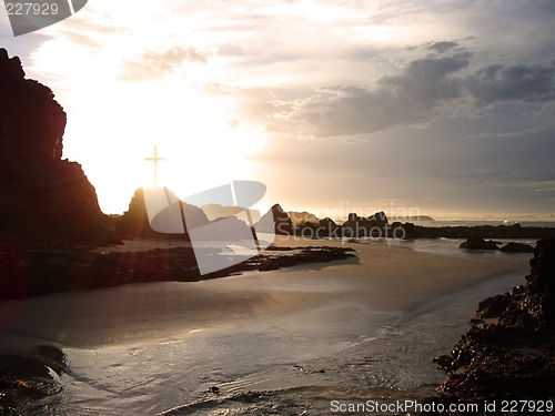 Image of glowing cross by the sea