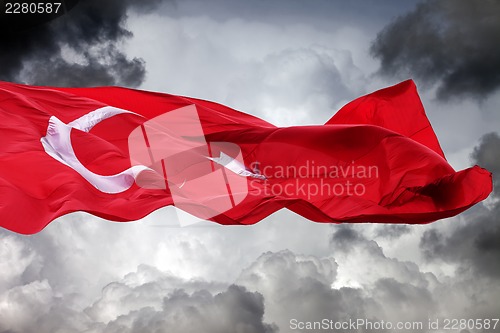 Image of Waving flag of Turkey against storm clouds