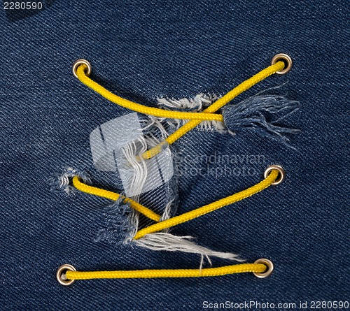 Image of Blue jean with hole and crisscross lacing