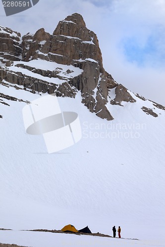 Image of Tents and hikers in snow mountains