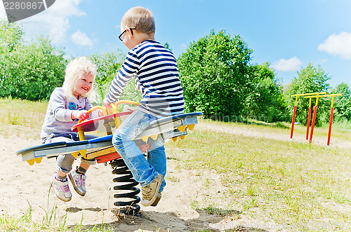 Image of Boy and girl swinging on a swing