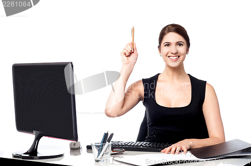 Image of Businesswoman holding pen and raising her hand