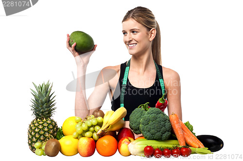 Image of Attractive girl with heap of fruits and vegetables