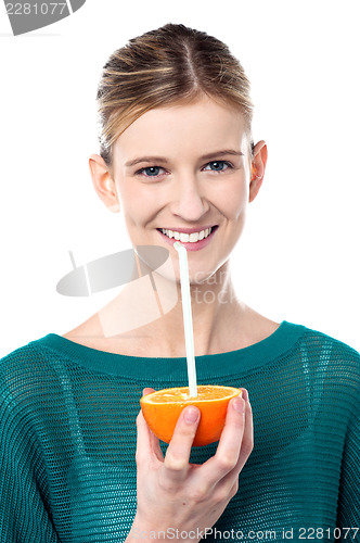 Image of Girl sipping orange juice through straw