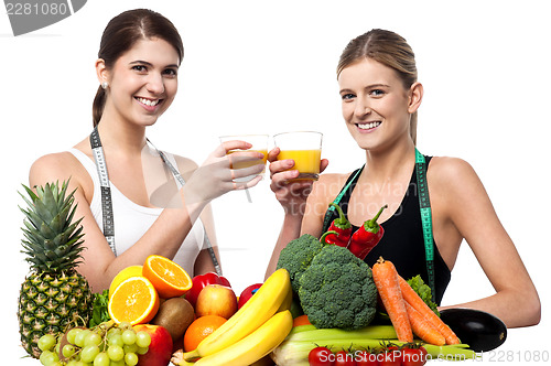 Image of Young smiling girls each holding glass of juice