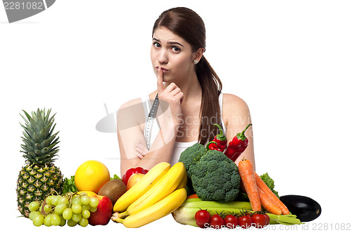 Image of Mischievous look of a young woman with fruits