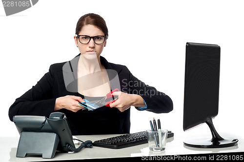 Image of Serious faced woman cutting her credit card