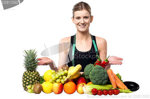 Image of Young smiling girl presenting fresh fruits