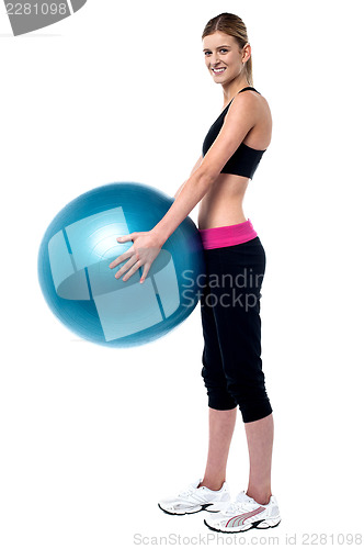 Image of Female fitness trainer holding swiss ball