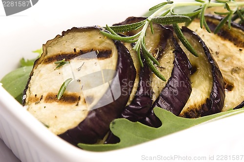 Image of Grilled eggplant slices on a plate with fresh rosemary